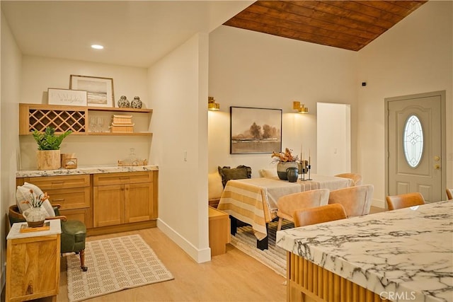 dining space featuring wooden ceiling, baseboards, light wood-type flooring, and lofted ceiling