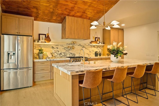 kitchen with wood ceiling, light wood-type flooring, decorative backsplash, stainless steel refrigerator with ice dispenser, and a sink