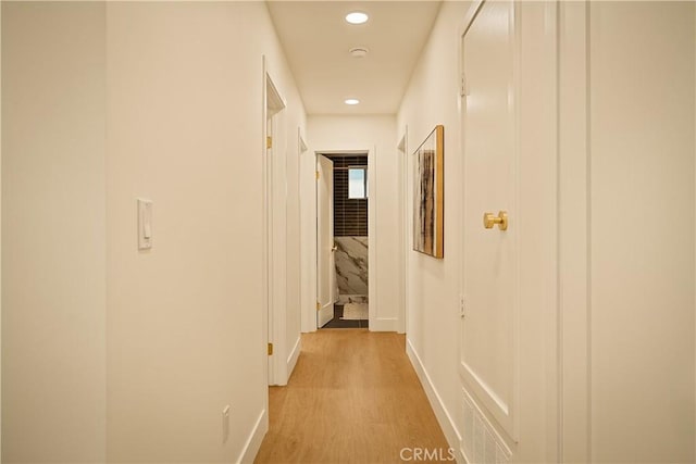 hallway with recessed lighting, light wood-type flooring, and baseboards