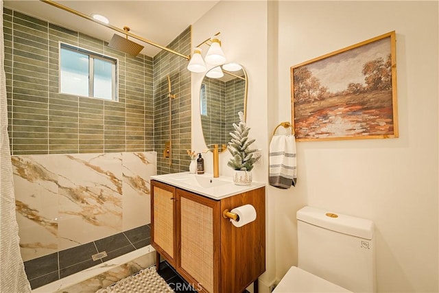 full bath featuring a tile shower, toilet, and vanity