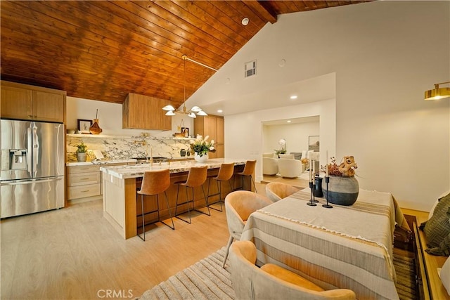 dining space featuring visible vents, high vaulted ceiling, light wood-style floors, wooden ceiling, and beamed ceiling