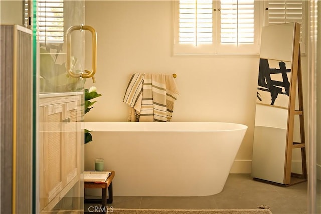 bathroom featuring tile patterned floors and a freestanding tub