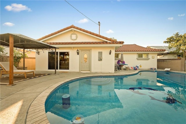 pool with a patio area and fence