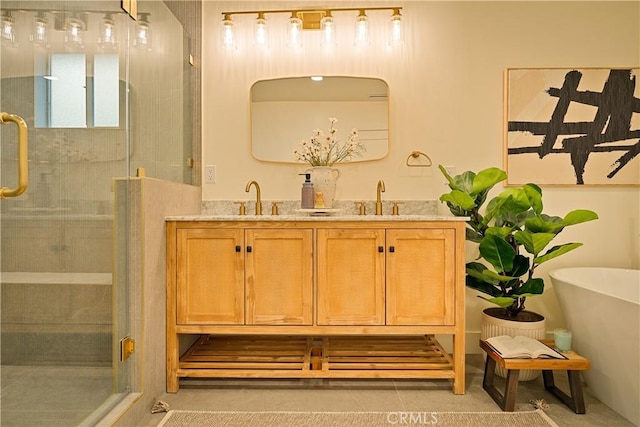 bathroom featuring double vanity, a stall shower, and a sink