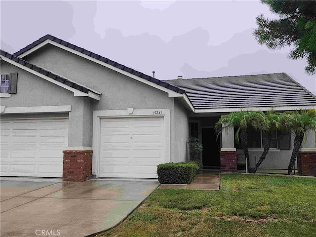 view of front of house with driveway, stucco siding, an attached garage, a front lawn, and brick siding