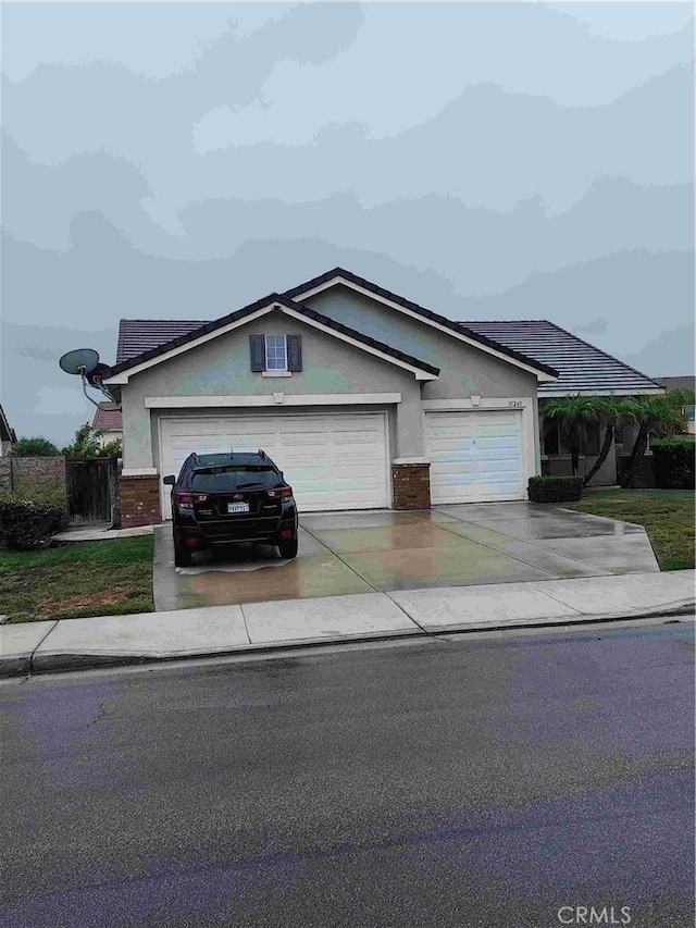 ranch-style house with concrete driveway, brick siding, an attached garage, and stucco siding