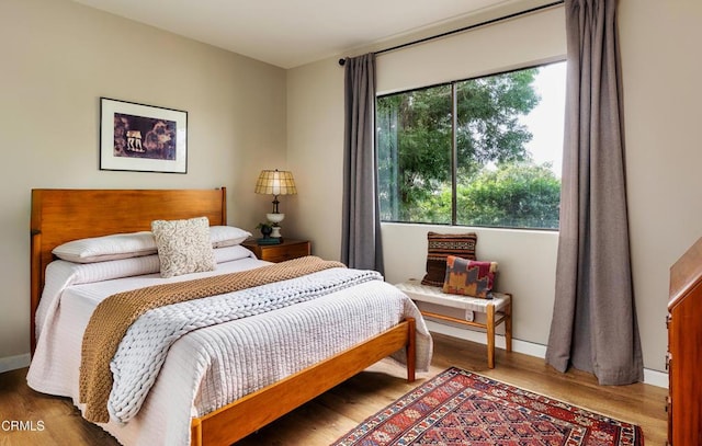 bedroom with baseboards and wood finished floors