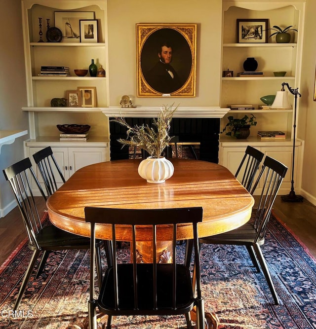 dining space with built in shelves, wood finished floors, and baseboards