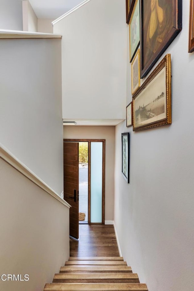 stairway with wood finished floors and baseboards