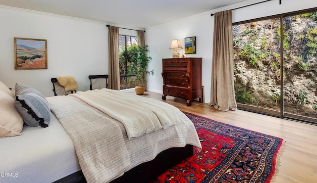 bedroom featuring ornamental molding and wood finished floors