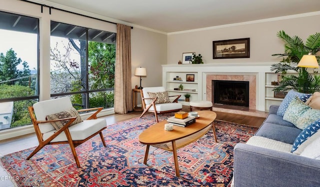 living area featuring a fireplace, wood finished floors, and crown molding