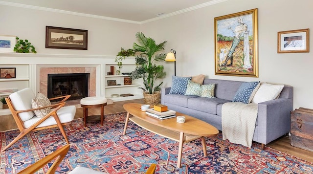 living room with ornamental molding, a fireplace, and wood finished floors