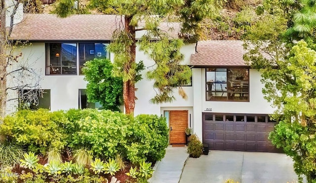 1868 Kaweah Dr, Pasadena, CA 91105 - view of front of house with stucco siding, a garage, driveway, and a shingled roof