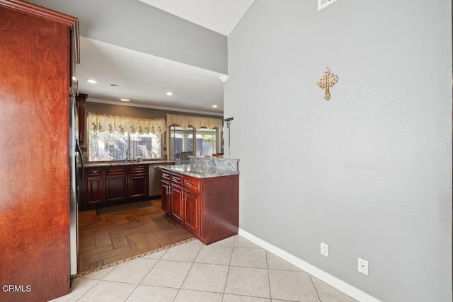 kitchen with reddish brown cabinets, baseboards, light stone countertops, stainless steel dishwasher, and recessed lighting