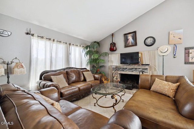 living room with lofted ceiling, a fireplace with raised hearth, and tile patterned floors