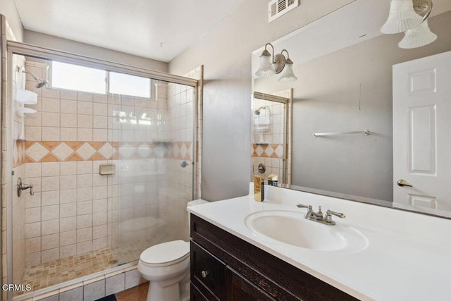 bathroom with toilet, a stall shower, vanity, and visible vents