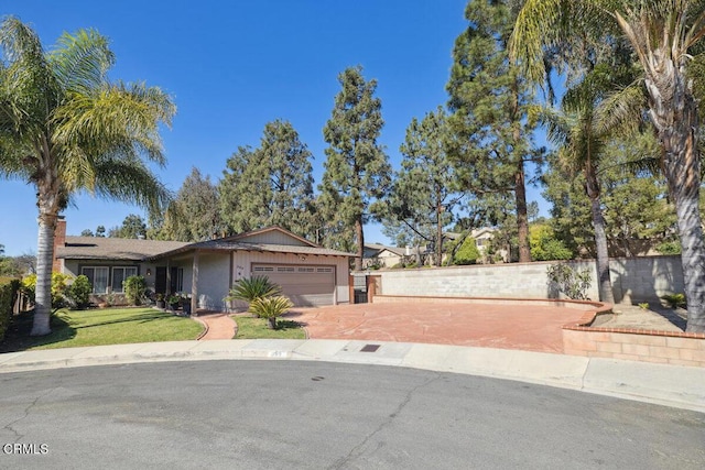 view of front of home featuring a garage, a front yard, and fence