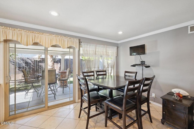 dining room with a wealth of natural light, crown molding, and light tile patterned floors