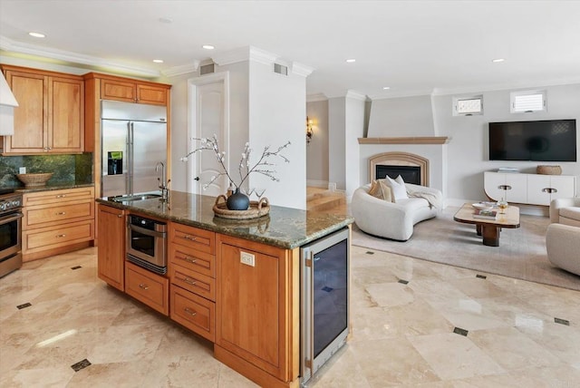 kitchen featuring wine cooler, a fireplace, stainless steel appliances, visible vents, and open floor plan