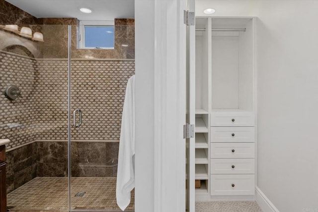 bathroom featuring a stall shower and baseboards