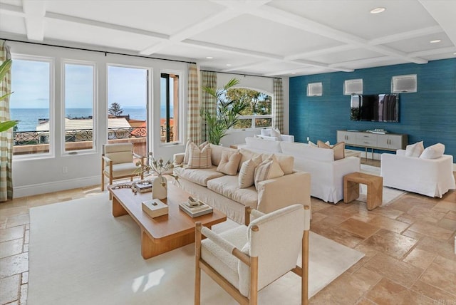 living area with an accent wall, coffered ceiling, stone tile flooring, and baseboards