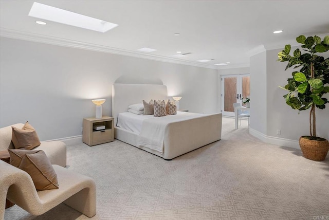 carpeted bedroom with a skylight, crown molding, baseboards, and recessed lighting