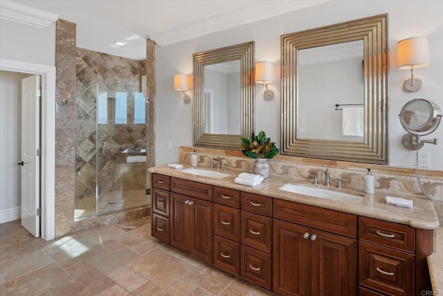 bathroom featuring a stall shower, ornamental molding, and a sink