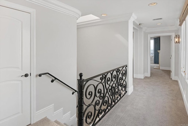 corridor featuring recessed lighting, visible vents, baseboards, ornamental molding, and carpet