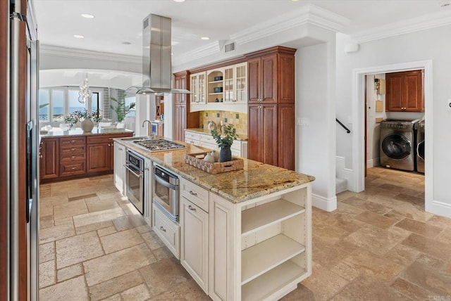 kitchen with island range hood, washer and clothes dryer, appliances with stainless steel finishes, stone tile flooring, and open shelves