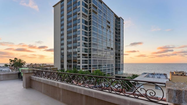 property at dusk with a water view