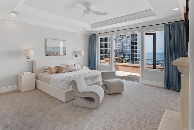 carpeted bedroom featuring ornamental molding, a tray ceiling, ceiling fan, and baseboards