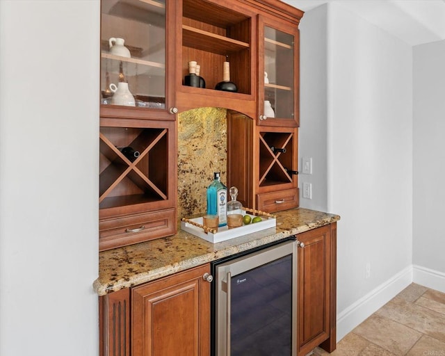 bar with a bar, wine cooler, and baseboards