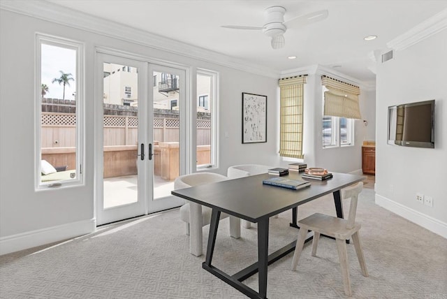 dining room with light colored carpet, crown molding, baseboards, and ceiling fan