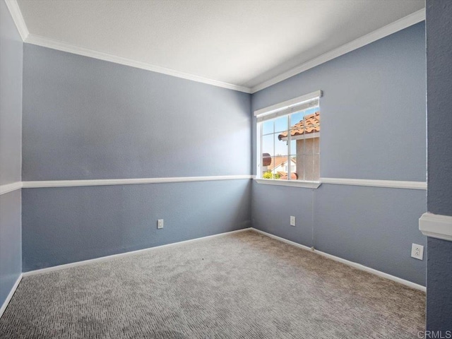 spare room featuring carpet floors, baseboards, and crown molding