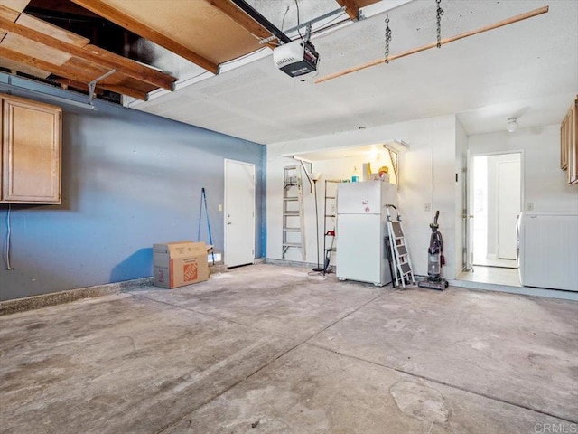 garage featuring washer / dryer, a garage door opener, and freestanding refrigerator