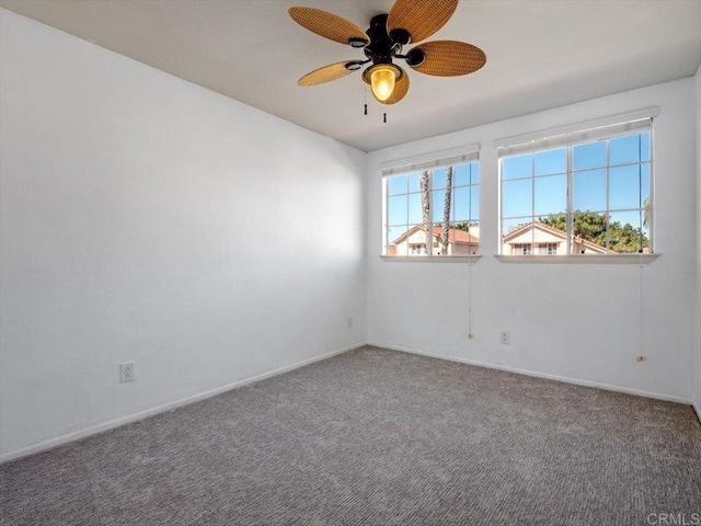 carpeted empty room with a ceiling fan and baseboards