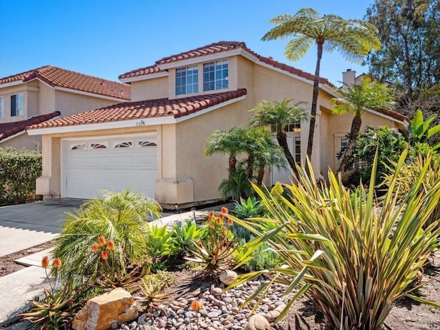 mediterranean / spanish home featuring a chimney, stucco siding, a garage, driveway, and a tiled roof