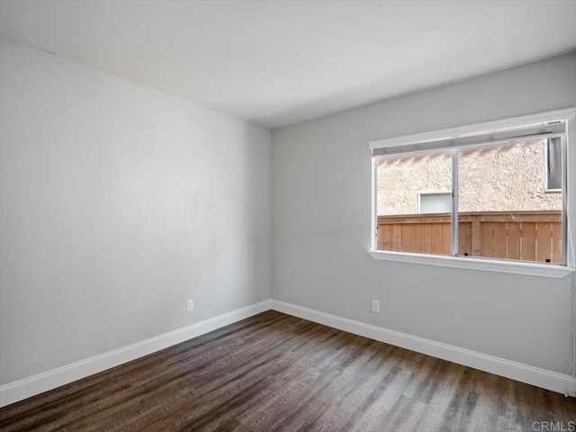 empty room featuring baseboards and wood finished floors