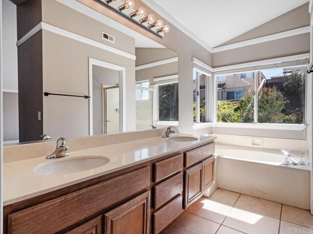 full bathroom with double vanity, vaulted ceiling, a sink, and tile patterned floors