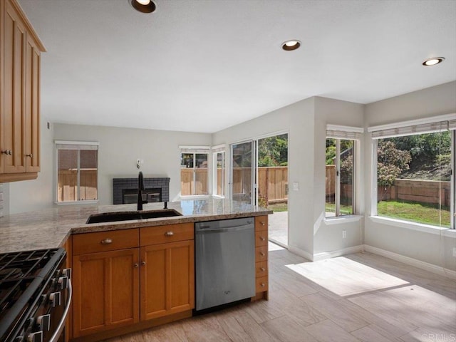 kitchen with recessed lighting, a peninsula, a sink, range with gas stovetop, and dishwasher