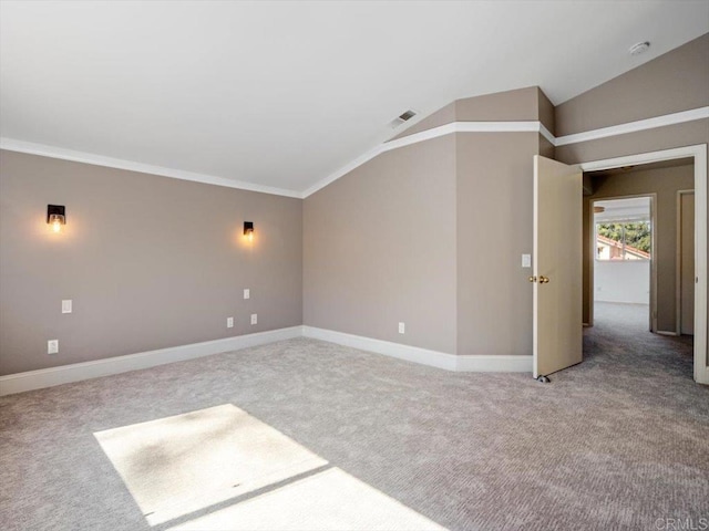 carpeted spare room with vaulted ceiling, ornamental molding, visible vents, and baseboards