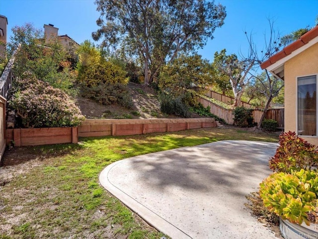 view of yard featuring fence and a patio