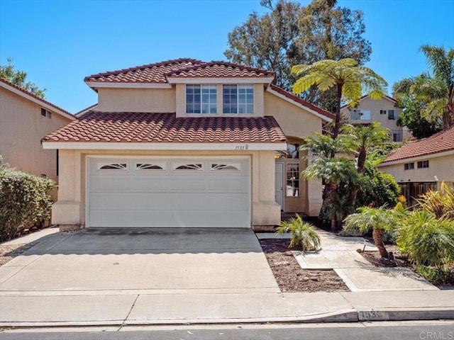 mediterranean / spanish house with a garage, driveway, a tiled roof, and stucco siding