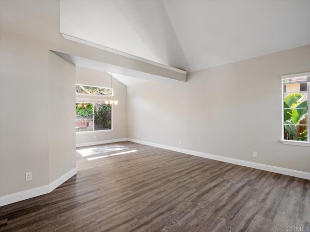 empty room with dark wood-style floors, a chandelier, high vaulted ceiling, and baseboards