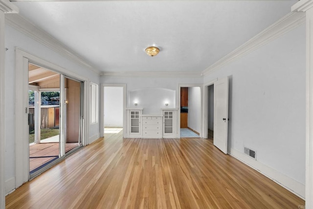 unfurnished living room featuring visible vents, crown molding, light wood-style flooring, and baseboards