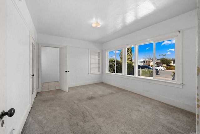 carpeted spare room with baseboards