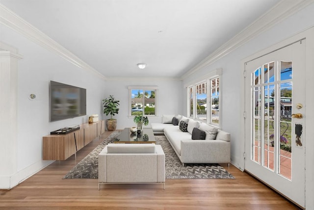 living area featuring light wood-style flooring and ornamental molding