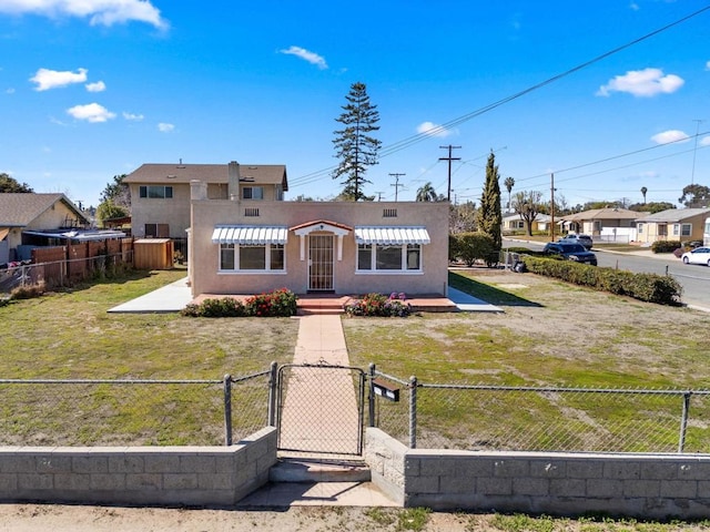 view of front of property with a fenced front yard, a front yard, a gate, and stucco siding