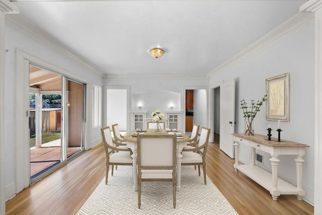 dining room with ornamental molding and light wood finished floors