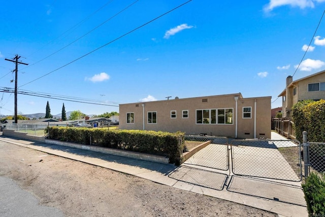 view of front of home featuring fence, a gate, and stucco siding